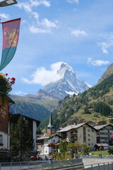 Picturesque view of Matterhorn mountain rising above traditional Swiss town. Combination of alpine...