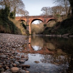Fototapeta premium Rustic arch bridge over a calm river