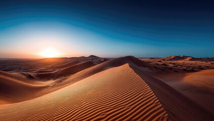 Sunrise over desert dunes. Vast expanse of golden sand dunes stretching into the distance under a vibrant sunrise
