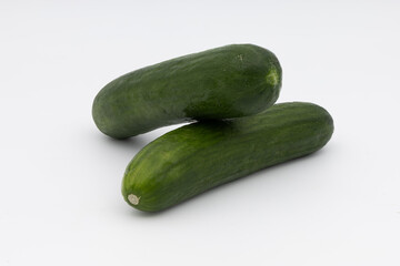 Two green cucumbers on white.
