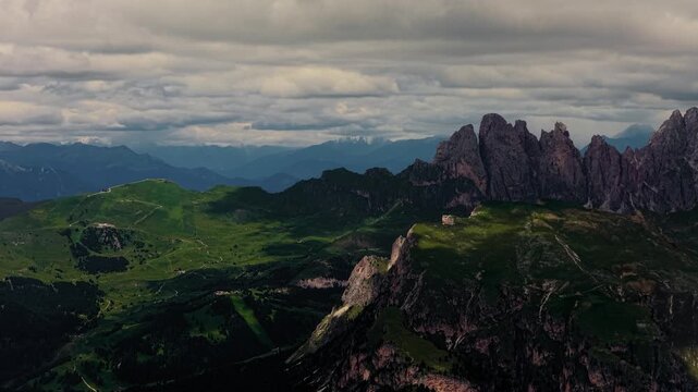 Drone aerial view of dramatic Seceda ridgeline and lush alpine slopes in the Dolomites, Italy