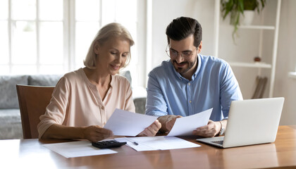 Adult Son Helping Senior Mother with Financial Documents and Planning for Retirement