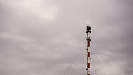 industrial metal chimney against cloudy sky