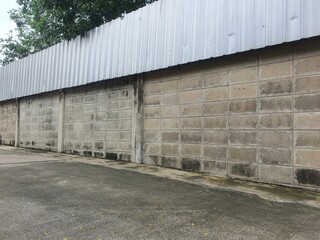 Concrete wall with corrugated metal sheet fence