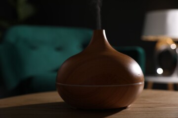 Modern aroma lamp on wooden table indoors, closeup