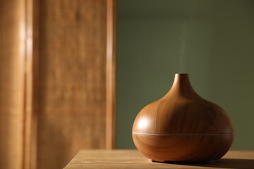 One stylish aroma lamp on wooden table indoors, closeup. Space for text