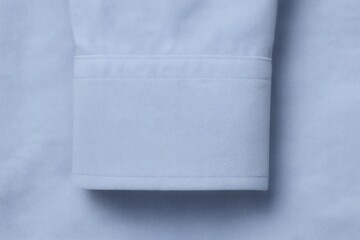 Fototapeta premium Cuff of a light blue shirt highlighting the intricate texture of the fabric along with the delicate stitching, showcasing elegance and style