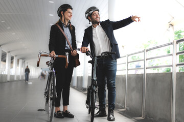 Commuting to work with bicycle. Businessman and businesswoman cycling to office in downtown district. Modern diversity people use eco transportation on city street. Environmental sustainable lifestyle