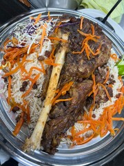 Kabuli pulao luxurious pilaf Afghan national dish closeup on the plate on the wooden table. Horizontal top view from above