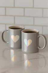 pair of coffee mugs with holographic heart designs on clean white background