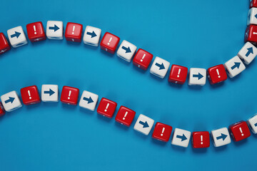 Red and White Dice with Arrows and Exclamation Marks on Blue Surface Displaying Low Feedback Loop and Decision Making Process