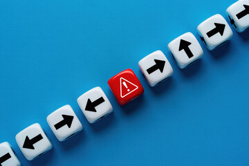 Warning Dice Among Directional Arrows on Blue Surface Illustrating Low Feedback Risk and Divergence in Decision Making Processes