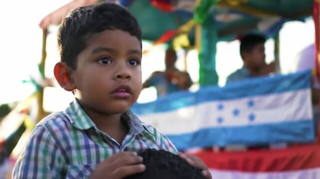 honduras independence day. young hispanic boy gazes during outdoor cultural event, sitting on his father's shoulders. parade with flags and decorations, festive atmosphere, national celebration