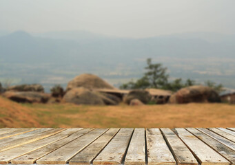 Wooden table top on blur mountain and grass field.Fresh and Relax concept.For montage product display or design key visual layout.View of copy space.
