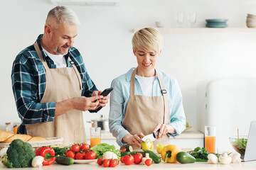Cook delicious meal together, healthy eating and vegetarian dish. Happy senior woman in apron...