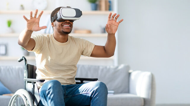 Black man in wheelchair exploring augmented reality in VR headset at home. African American guy with disability playing virtual online game. Futuristic technologies concept - Powered by Adobe