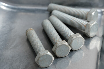 Construction essentials in a metallic workspace with bolts and screws