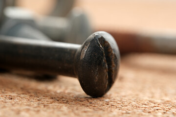 Close-up of rusty screws on a wooden surface in a workshop