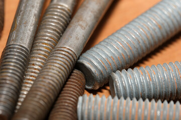 Collection of various metallic bolts and screws on wooden surface