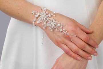 Description
A close-up photograph focuses on the hands of a bride, adorned with elegant silver and...