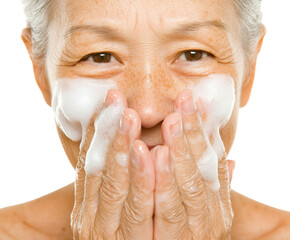 Aging Gracefully: A Close-Up of a Mature Woman Washing Her Face with Gentle Cleansing Foam Against a Dark Background, png, isolated on white background