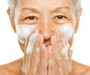 Aging Gracefully: A Close-Up of a Mature Woman Washing Her Face with Gentle Cleansing Foam Against a Dark Background, png, isolated on white background