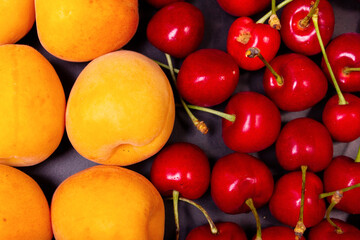 Apricots and cherries on a black background