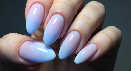 Close up of a hand with long almond shaped nails painted with a light blue and white ombre effect