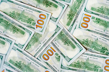 a lot of money banknotes of one hundred 100 American dollars lie on the table in different order, mixed and piled up, the background is piled up with money American green dollars, wealth