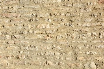 Wall of gray stones held together with brown cement