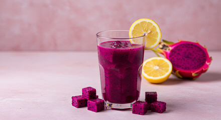 A glass of dragon fruit lemonade, vibrant purple color with dragon fruit cubes and lemon slice garnish. Placed on the side with dragon fruit halves and lemon wedges nearby.