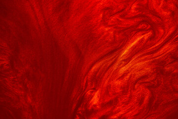 Shimmering red abstract background. Liquid glitter paint texture waves and swirls. Beautiful shiny...