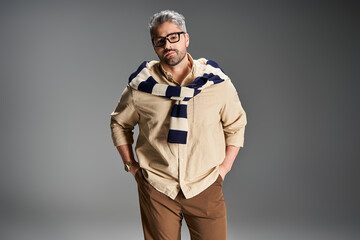 Stylish man in glasses showcases elegant fashion in studio setting with modern flair