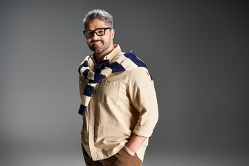 Handsome man in stylish glasses showcasing an elegant outfit in a studio setting