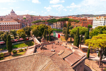 Panoramic view of Vatican City and Rome, with St. Peter Basilica dome and lush green trees in foreground