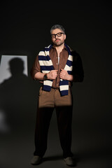 Stylish man in glasses showcases elegance and fashion in studio environment