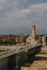 Tortosa’s prominent bell tower and bridge create a striking cityscape with mountains forming a distant backdrop.