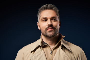 Handsome man radiates confidence in stylish attire against a dark studio backdrop