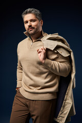 Handsome man with stylish outfit posing confidently in modern studio environment