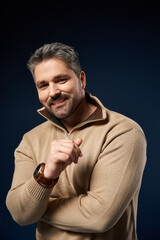 Handsome man showcasing a trendy outfit in a studio setting during a fashion shoot