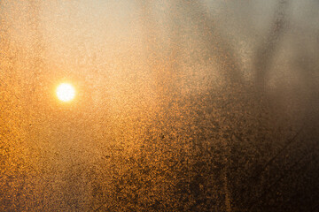 Steamy window with orange sun shining through