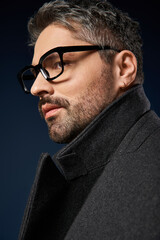 Obraz premium Stylish man in glasses showcasing elegance in a sleek studio setting