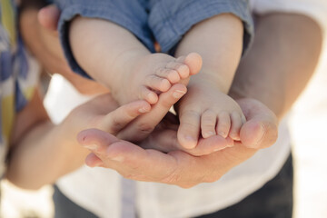 Babyfüße in schützender Hand – Symbol für Familie, Geborgenheit und Liebe