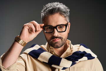Stylish man with glasses poses elegantly in studio setting for fashion showcase