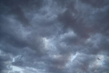 Stratocumulus clouds, dark clouds with barely visible light streaks resembling traces of an...