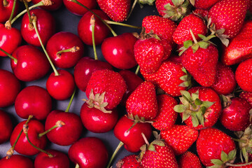 Strawberries and cherries on a black background