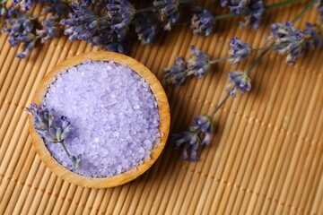 Lavender bath salt and lavender flowers on wooden background. Top view, space for text