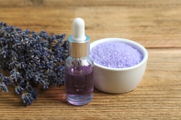 Essential oil and lavender salt on wooden background - beauty treatment. Space for text
