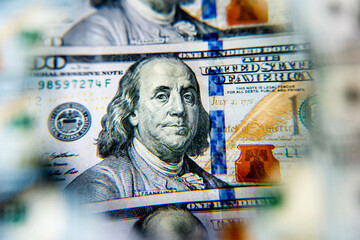 american greenbacks bill of 100 hundred dollars enlarged under magnifying glass slightly out of...