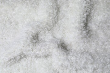 New soft white curly teddy fleece plush throw blanket or pillow case. Abstract fabric texture background with curles. Top view, closeup